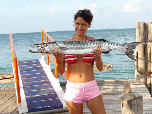 Angler holding a barracuda caught while fishing in Cancun