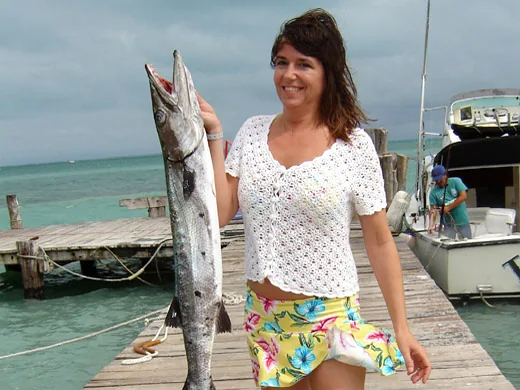 Angler holding a barracuda caught while bottom fishing in Cancun