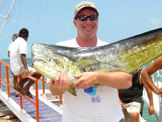 Angler holding a mahi-mahi caught while fishing in Cancun