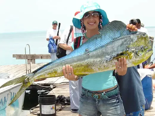 Angler holding a large mahi-mahi caught while fishing in Cancun