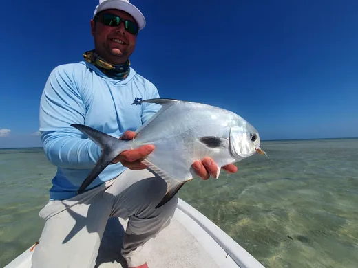 Angler holding a permit caught while fishing at Isla Blanca