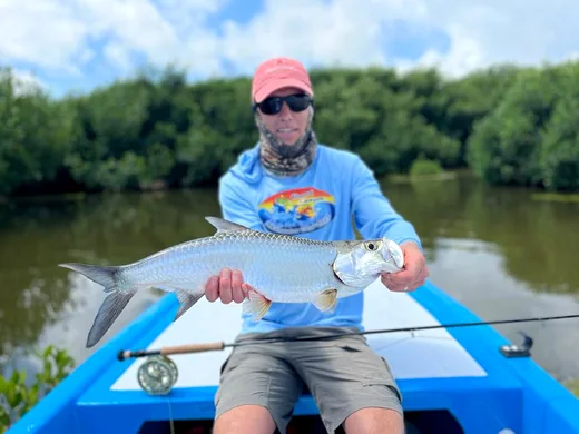 Angler holding a tarpon caught while fishing at Isla Blanca